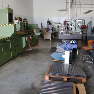 The grinding department handles jobs like grinding the tops of steel lathe beds, mill columns and rotary tables. This part of the operation is enclosed in a separate room to keep the abrasive grinding dust out of the rest of the shop. The big grinder to the left can now do up to 50 rotary tables at a time.