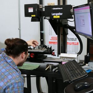 Laser marking is done in this department. Taylor loads a chuck to receive its laser engraved markings.