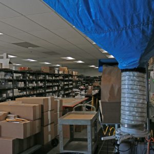 On the left of the picture are shelves of finished, boxed product ready to be pulled by the shipping department as needed.